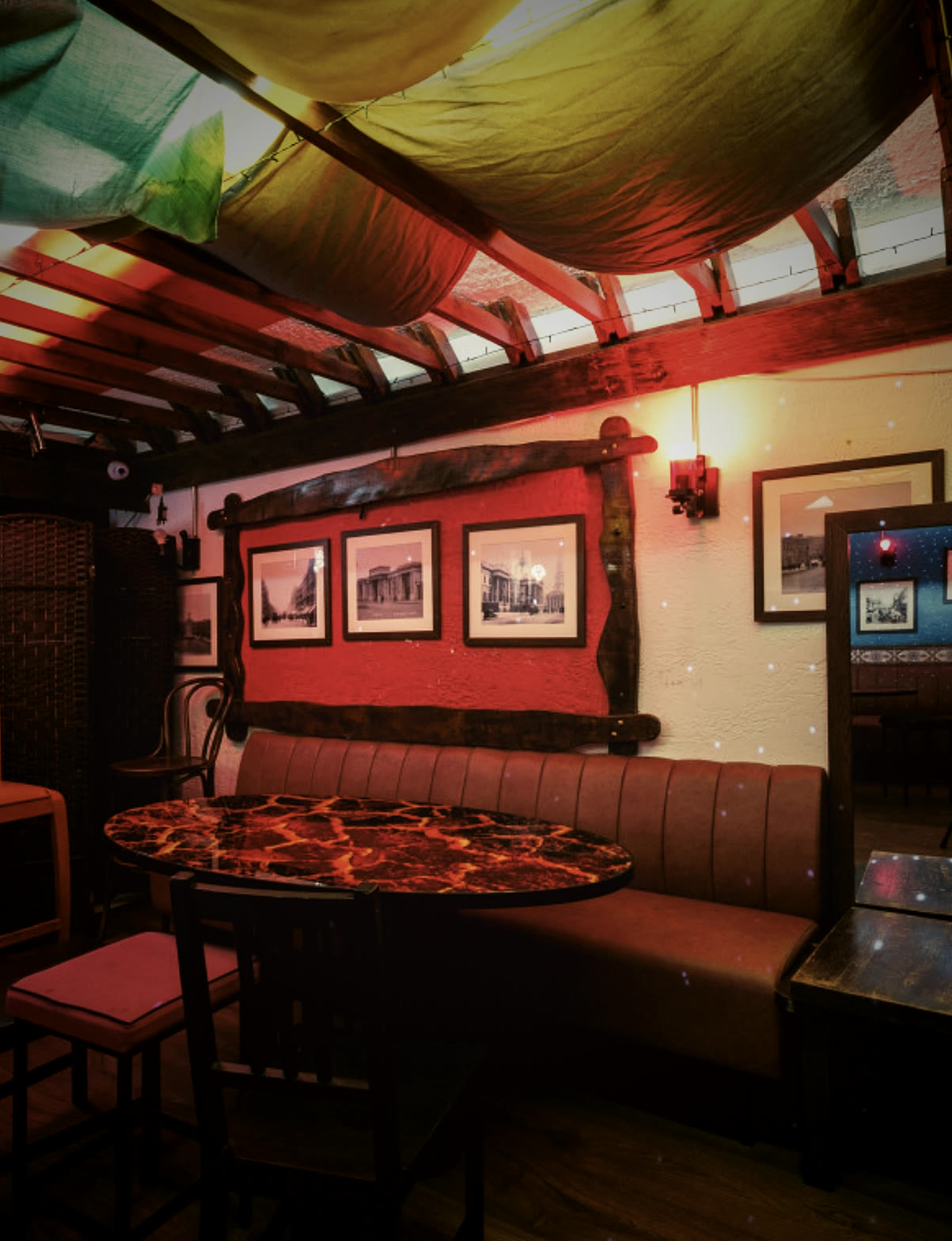 Red leather booths and a round table beneath colourful drapes