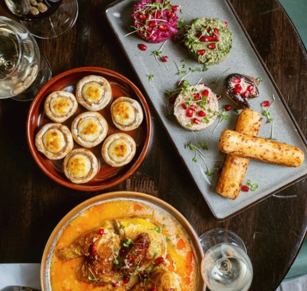 A table of Georgian dishes at Violet's: mushroom soko, pkhali with pomegranate, cheese sticks and a stew