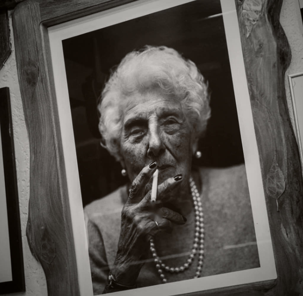 Framed black and white portrait of Violet, the Queen of Soho, with a cigarette and pearls